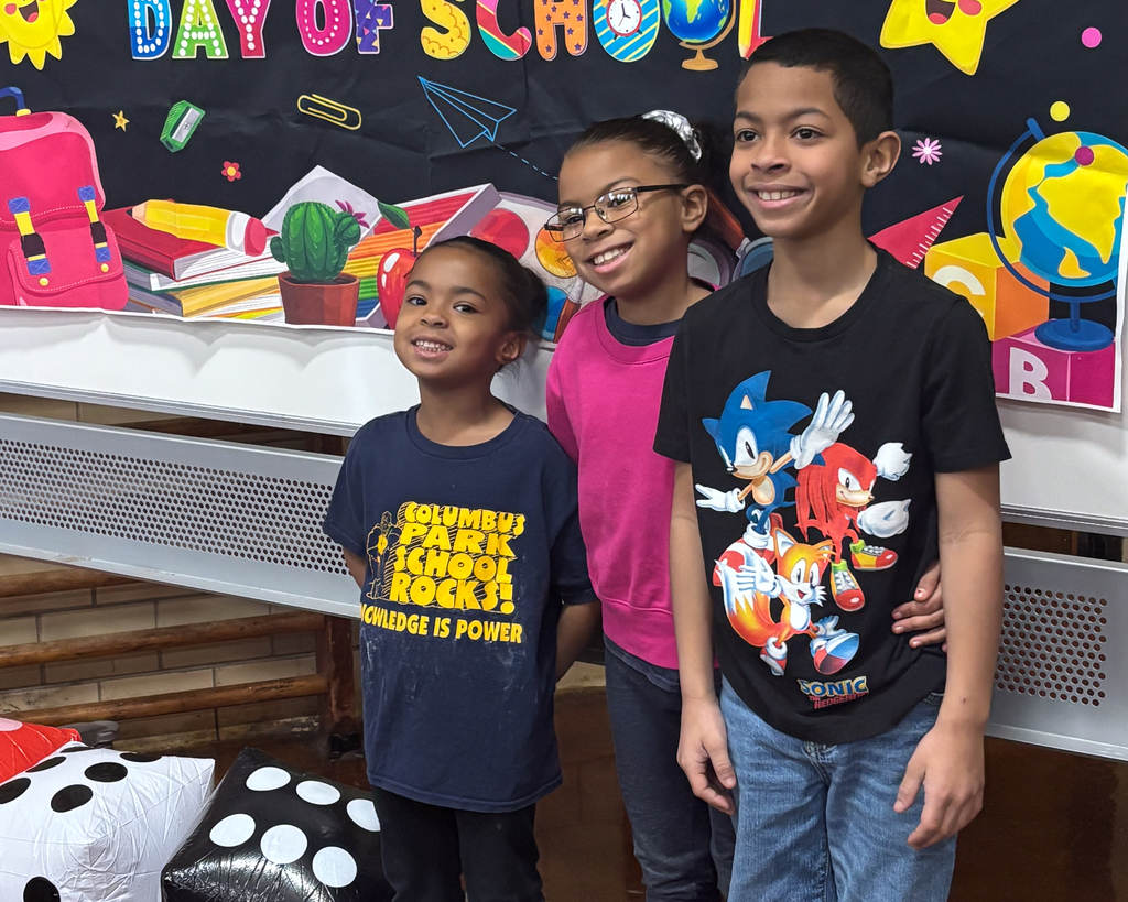 Three students stand together and smile for a photo.