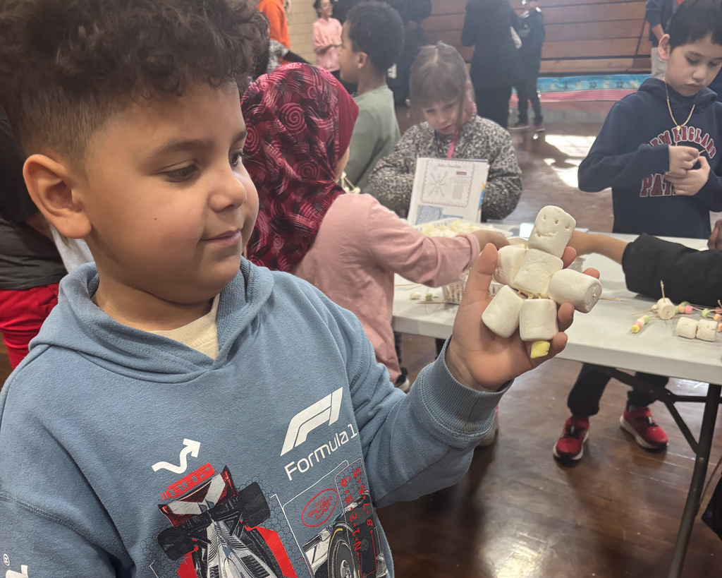 One student shows off their marshmallow figure following a project.