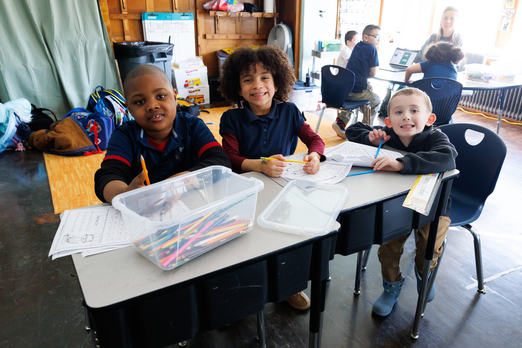 Three students pause for school work to smile for a photo.