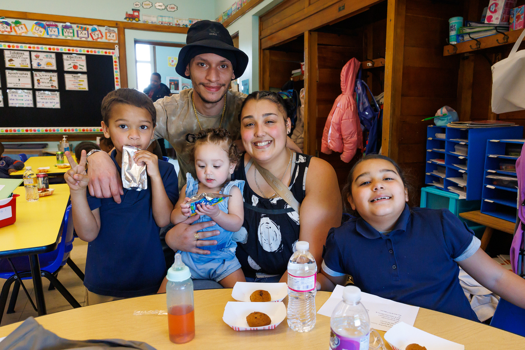 A family of five smile for a photo during an after-school tutoring event. 