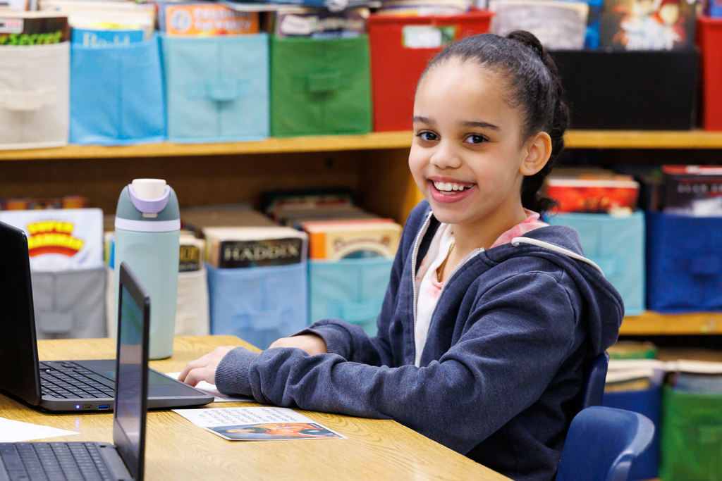 A student smiles while doing school work.