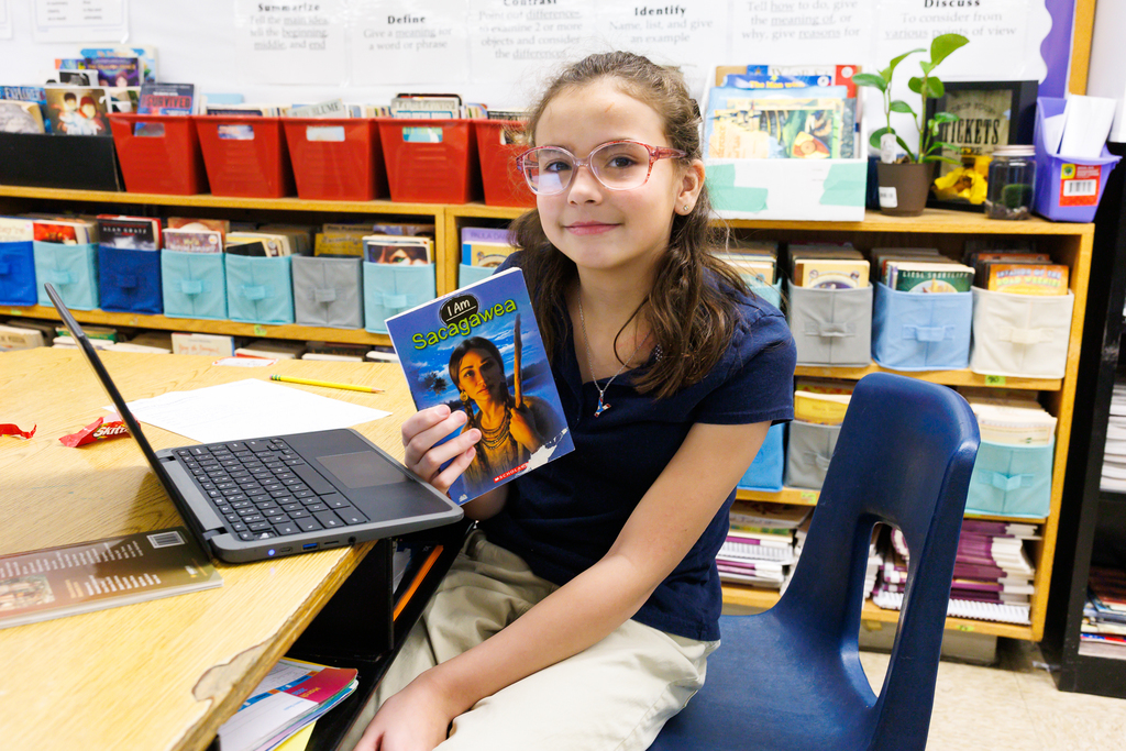 A student holds up a book about Sacagawea.