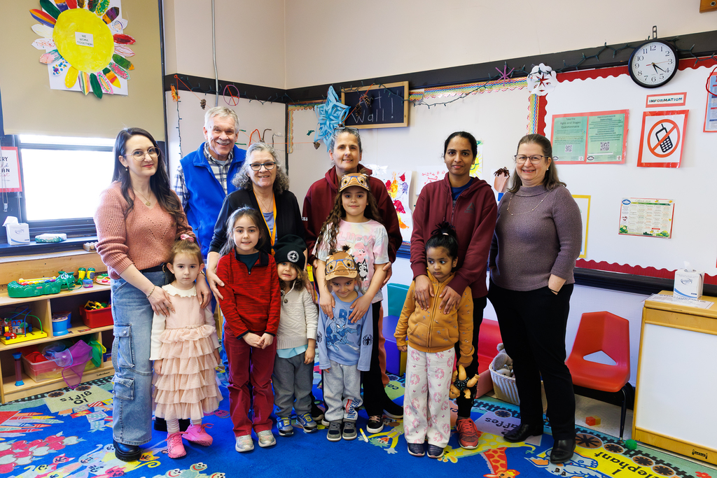 Children and adults stand together for a photo.