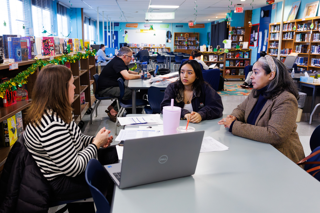 A student and their parent speak with a MassEdCo rep about financial aid.