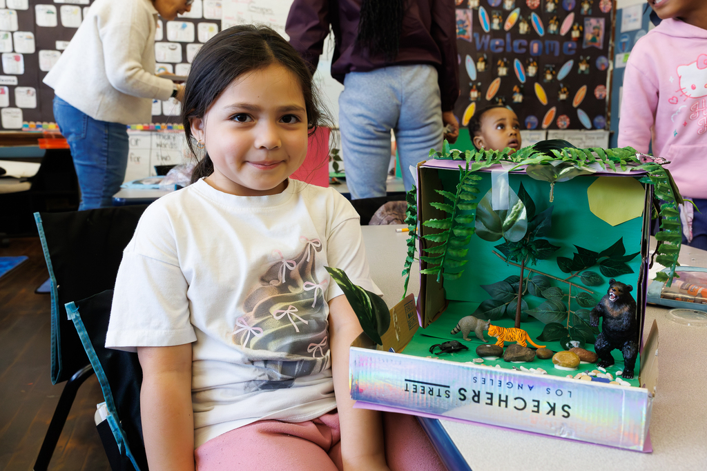 A student smiles while showing off their 3D habitat.