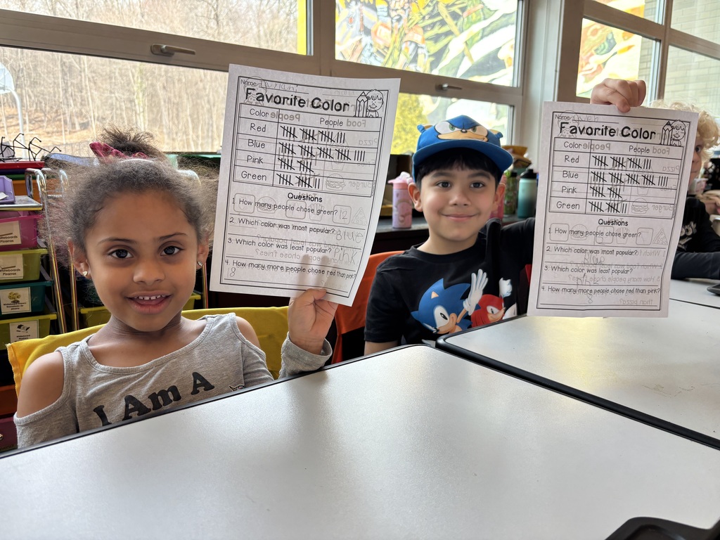 Smiling children holding worksheets
