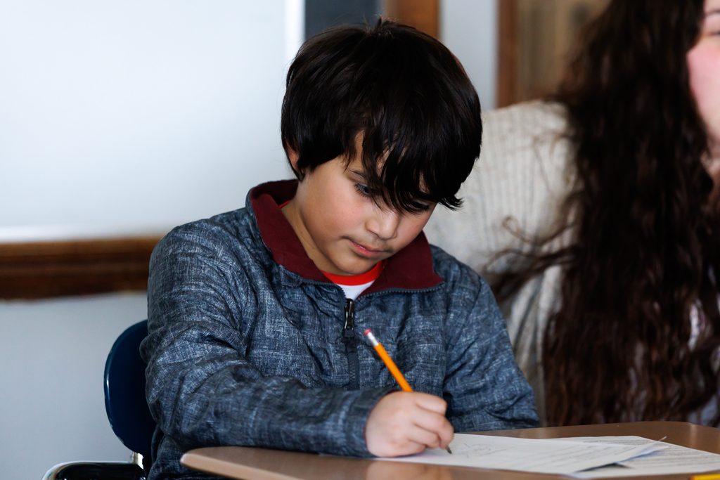 A student works on an open response essay during an after-school writing club.