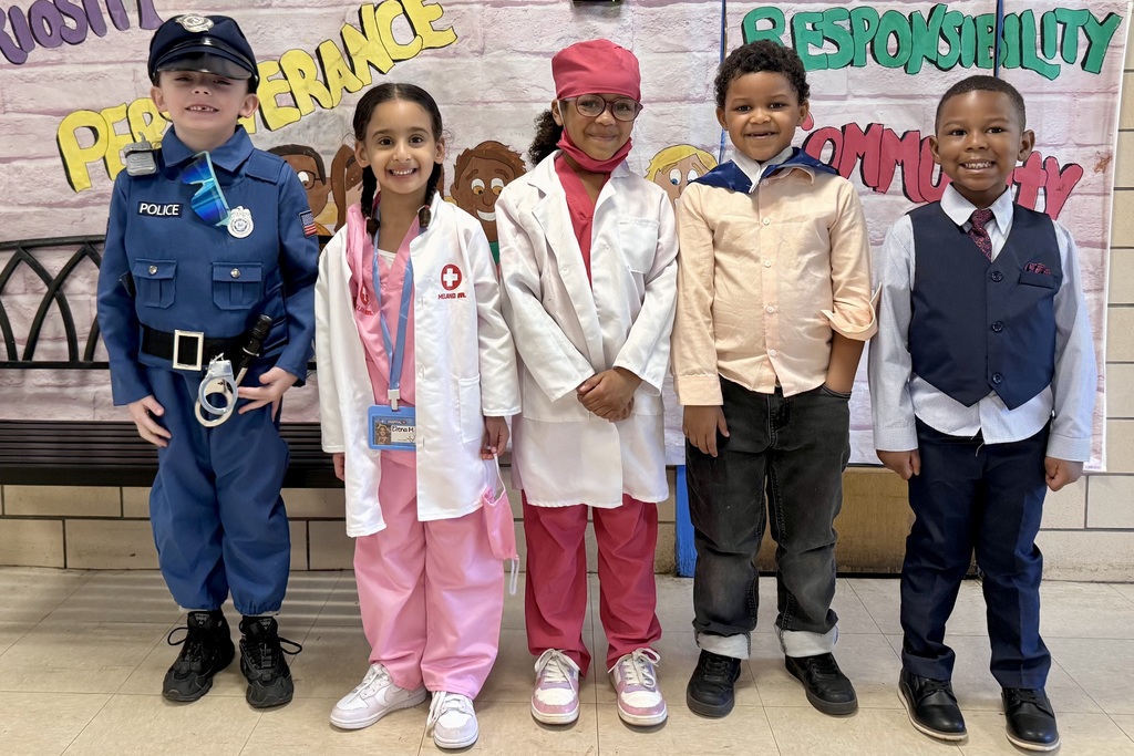 Five children dressed in career costumes stand together, smiling.