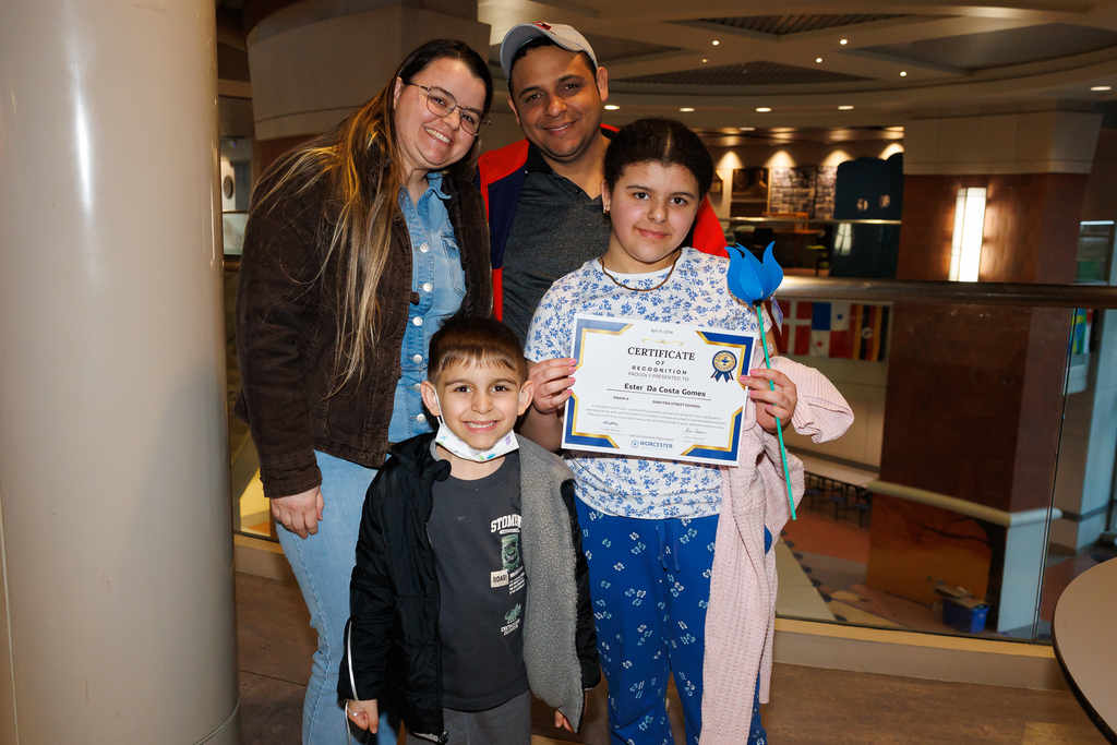 A family of four take a photo together.