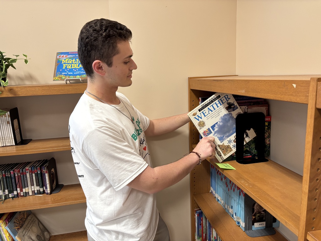 A volunteer placing a library book on a shelf