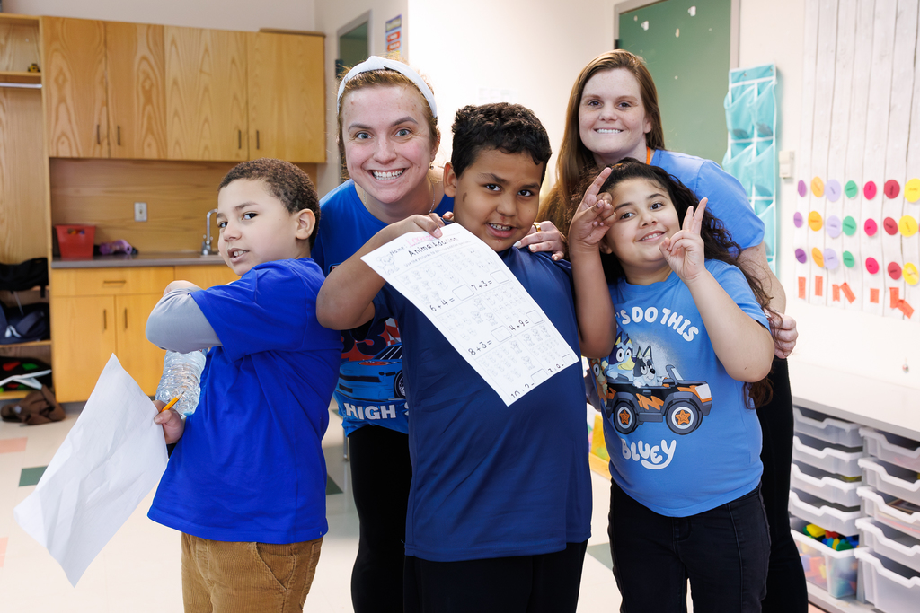 Teacher and students stand together wearing blue to close out Autism Awareness Month.