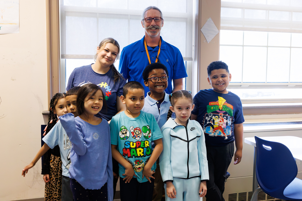 Teacher and students stand together wearing blue to close out Autism Awareness Month.