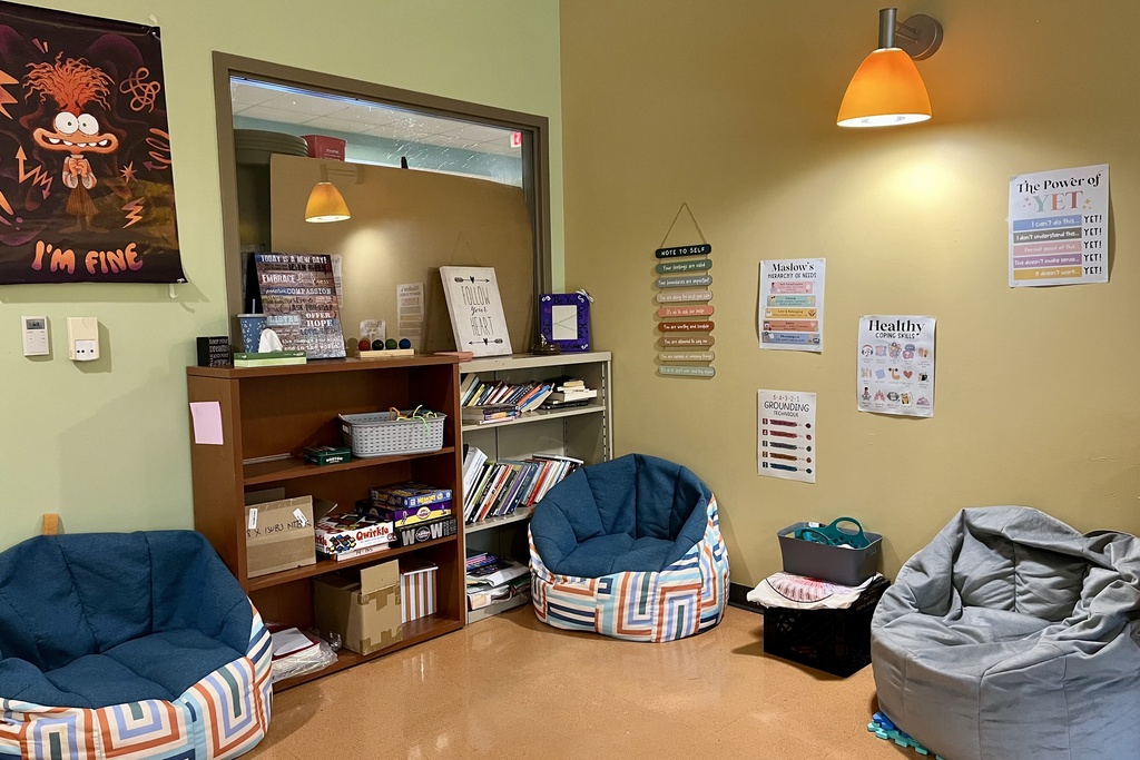A cozy room with beanbag chairs, bookshelves, and motivational posters on the walls.
