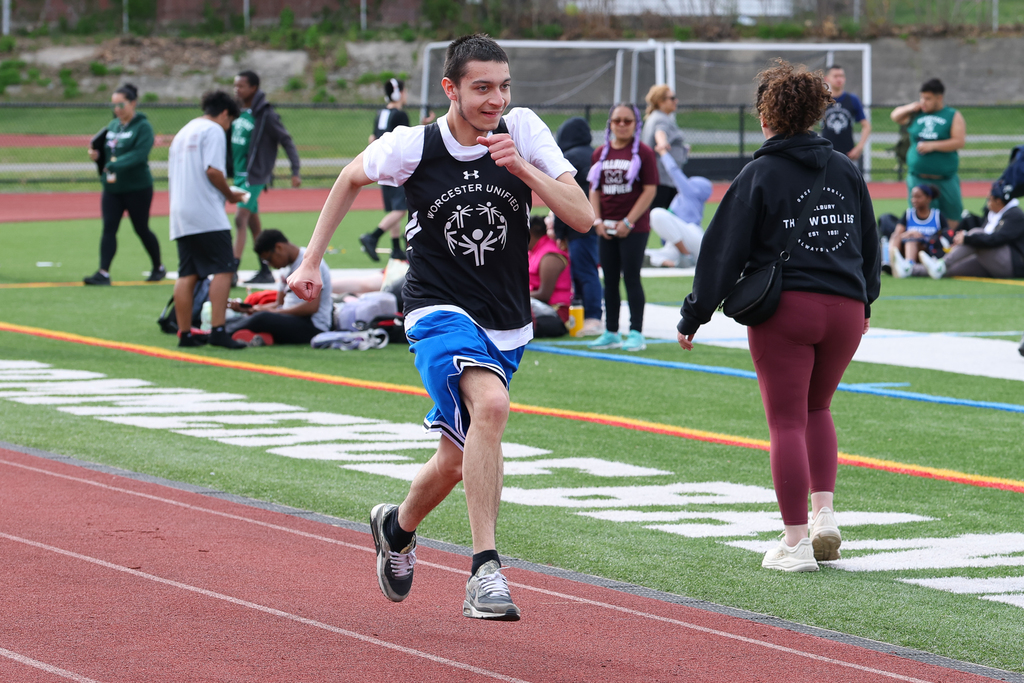 A student runs on the track during a track and field meet.