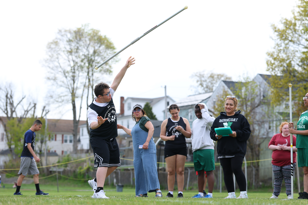A student lets go of the javelin, throwing it through the air, during a track and field meet.