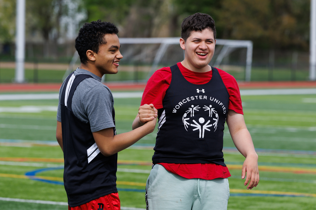 Two students slap five before a track & field meet.
