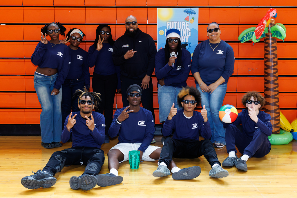Principal Sam FanFan stands for a photo with a group of students, all wearing sunglasses.