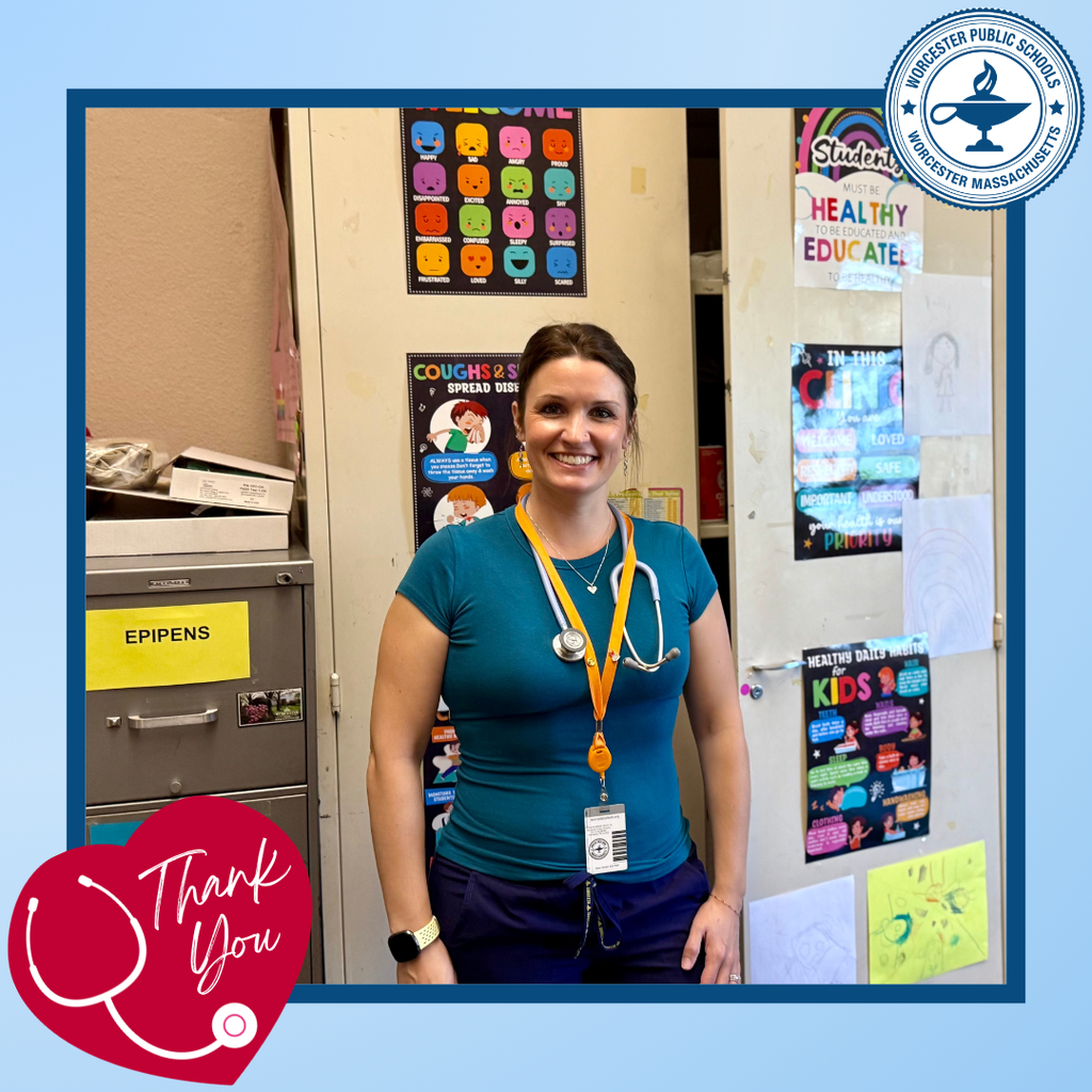 A smiling nurse stands in a room decorated with educational posters about health and emotions.