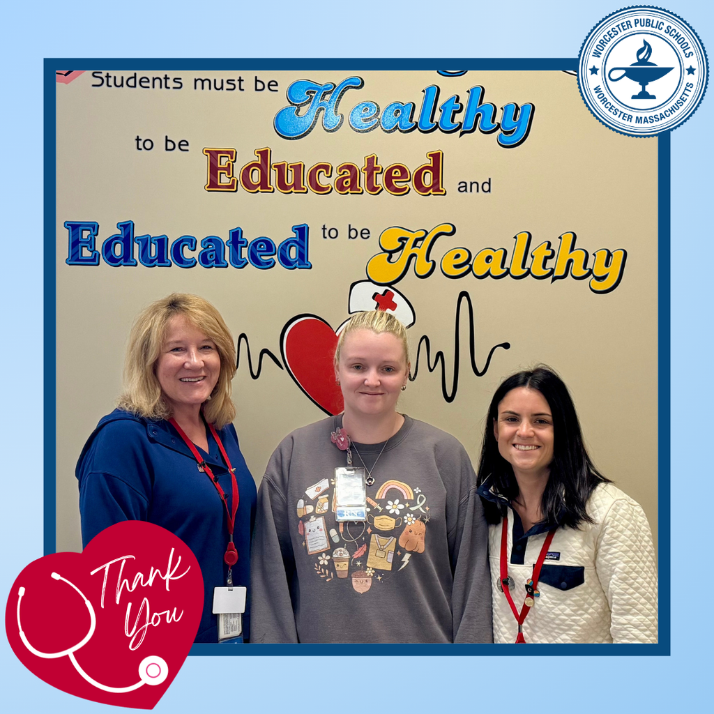 Three women stand in front of a mural that reads 'Students must be Healthy, Educated and Educated to be Healthy'.