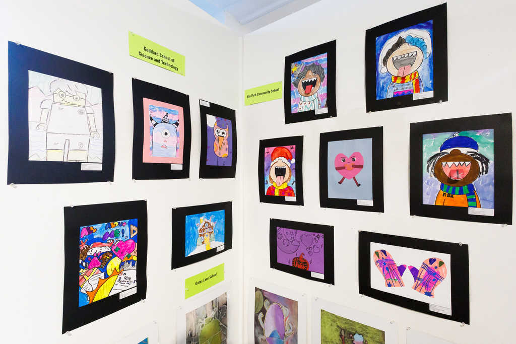A wall of colorful artwork on display from various schools.