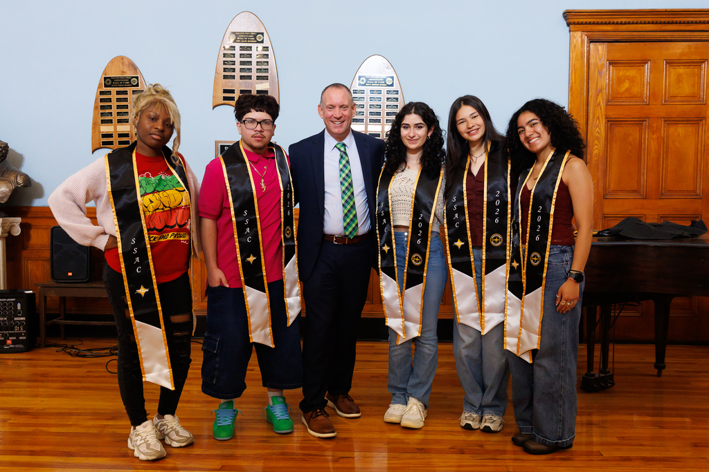 Five students stand beside Superintendent Allen on stage.