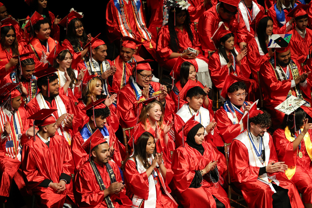 A crowd of high school graduates wearing red caps and gowns.