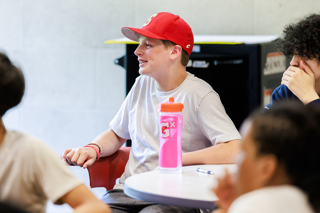 A student smiles while listening to a infosession.