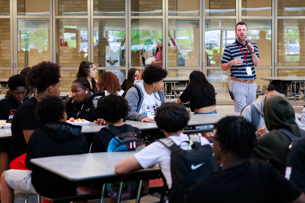 An administrator talks to a room full of eighth grade students.