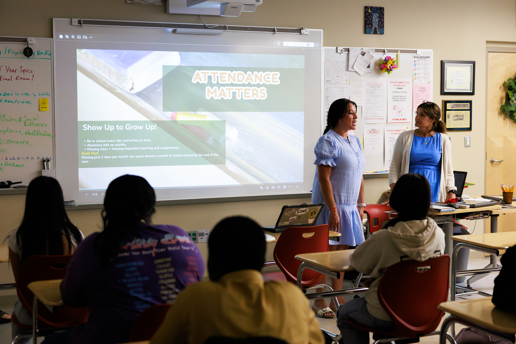 A teacher discusses with students the importance of attendance.