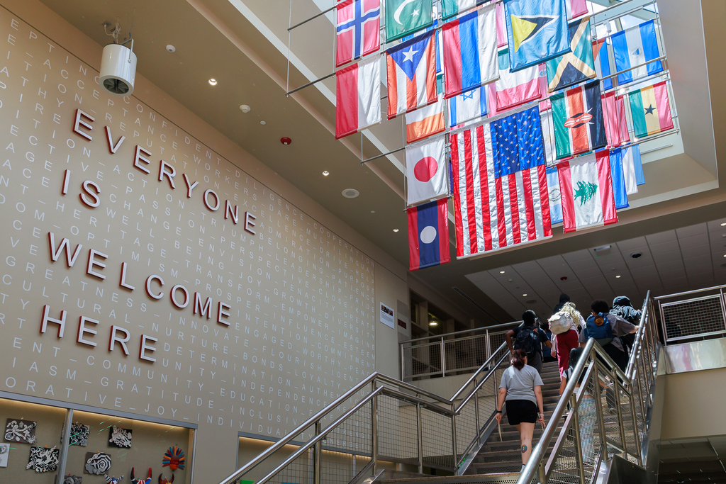 Students walk through the halls of South High. A banner is visible that reads "Everyone is Welcome Here."