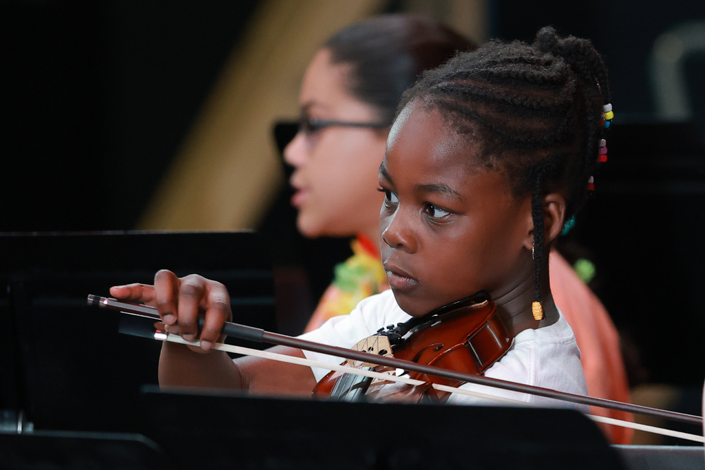 A student is focused while playing the violin.