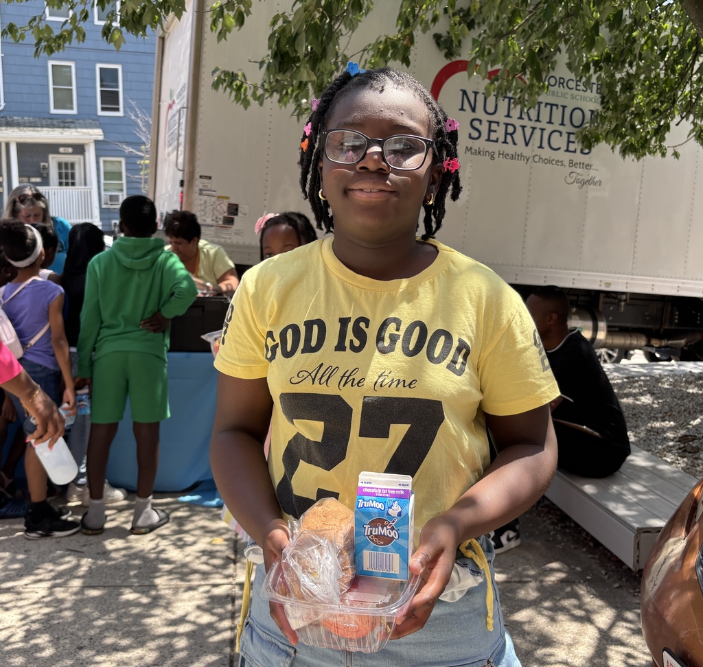 A young girl in a yellow t-shirt holds a meal package with a carton of TruMoo milk.