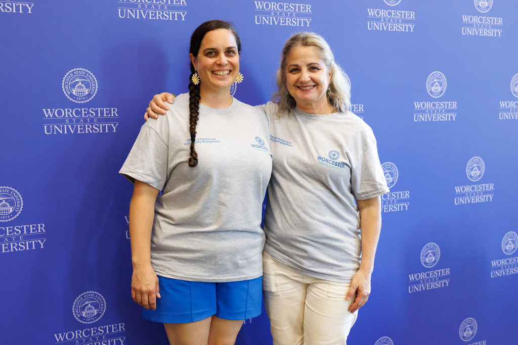 Two woman stand side-by-side against a Worcester State University step-and-repeat banner.