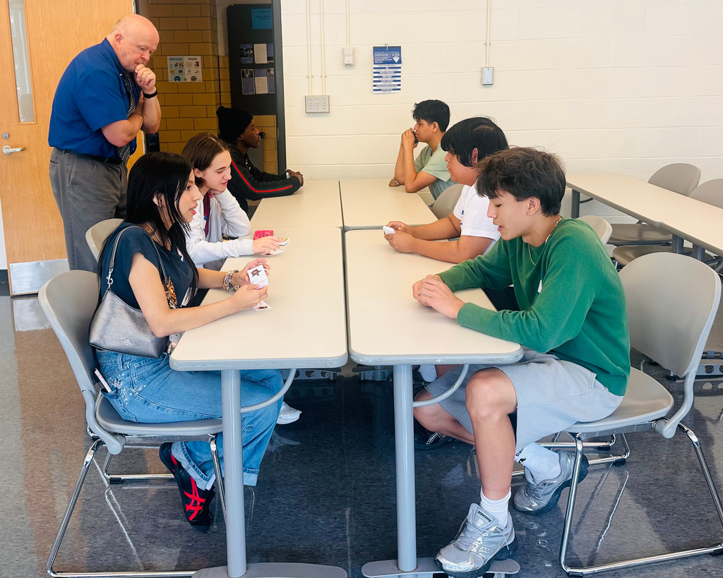 Students sit around a table practicing their networking skills.