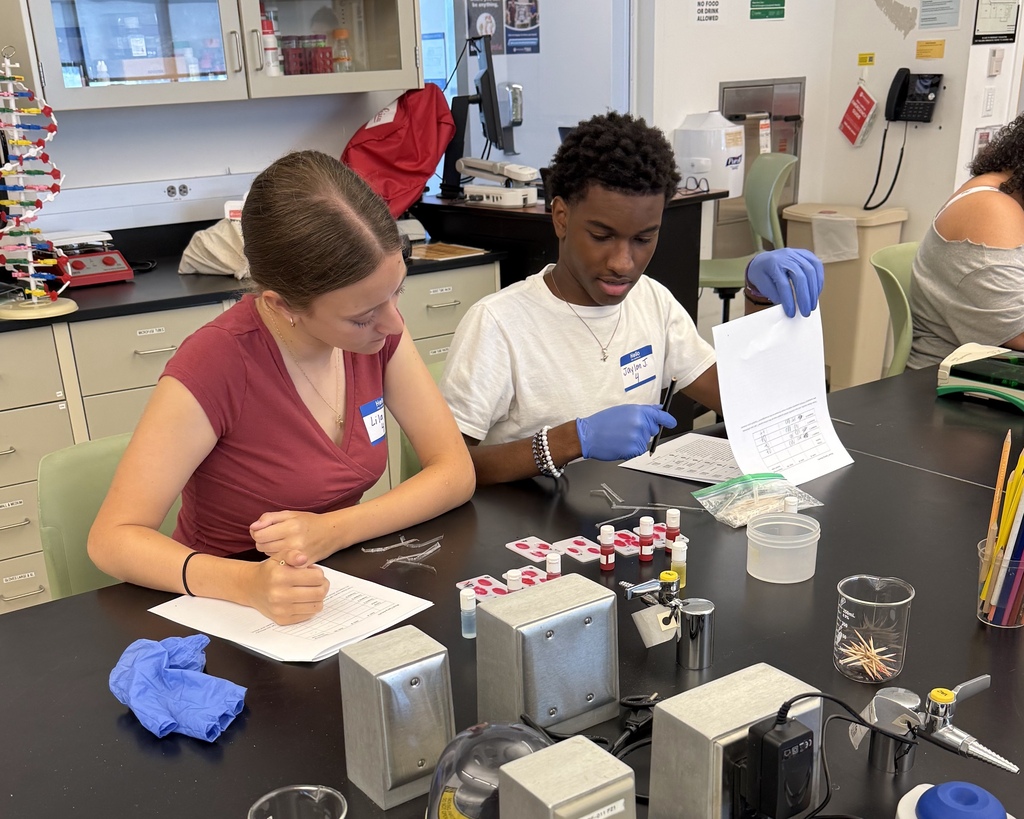 Two students work together in a scientific lab setting.