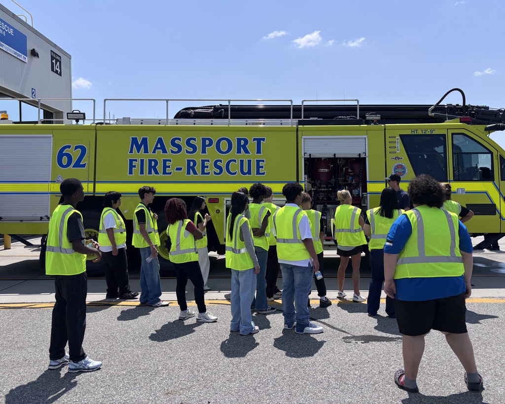 Students in visibility fests stand in front of a Massport Fire & Rescue truck.