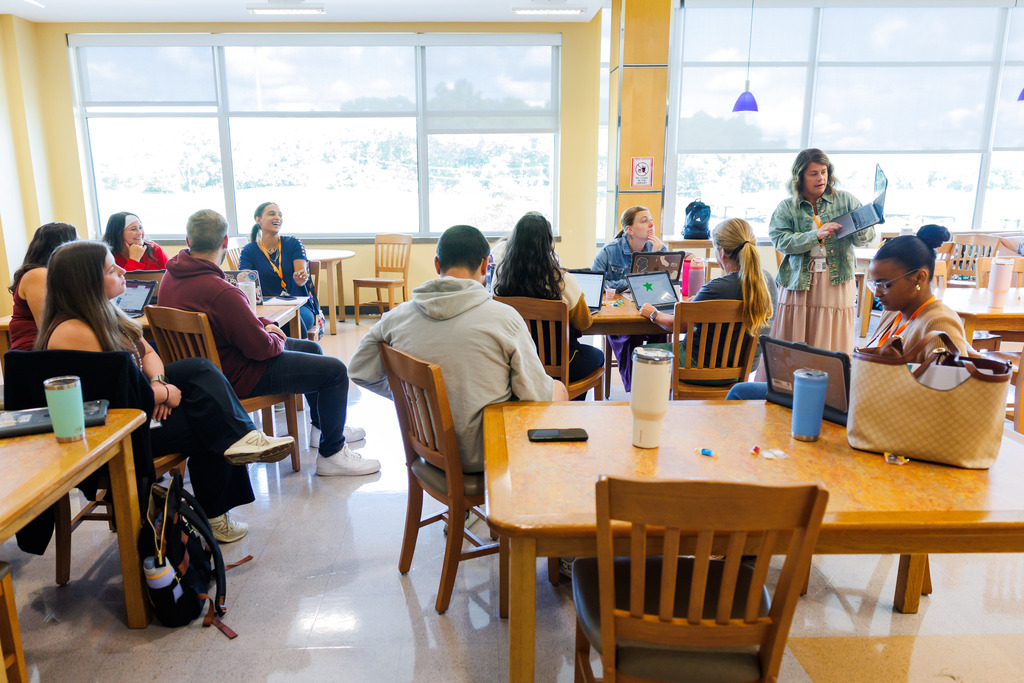 A woman leads new staff through an orientation session.