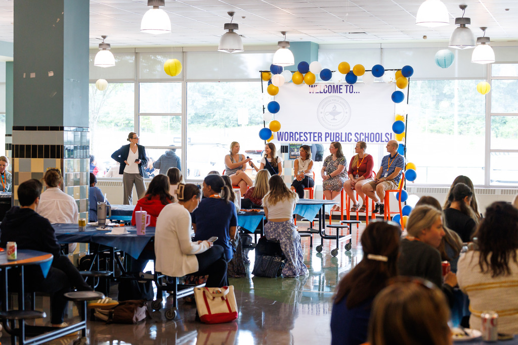 A room full of new educators listen during a panel discussion.