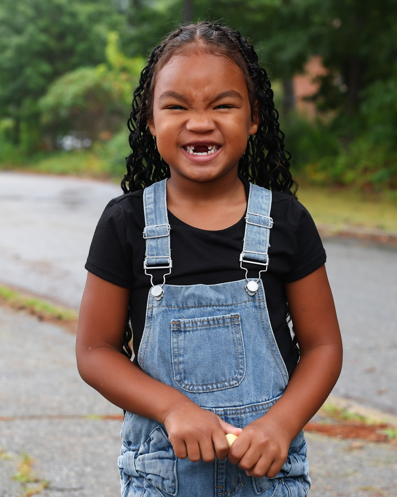 A young student smiles on the first day of Pre-K and Kindergarten.