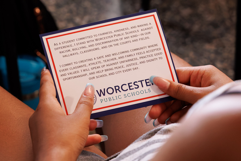 A student holds a card with the Stand Against Racism pledge.