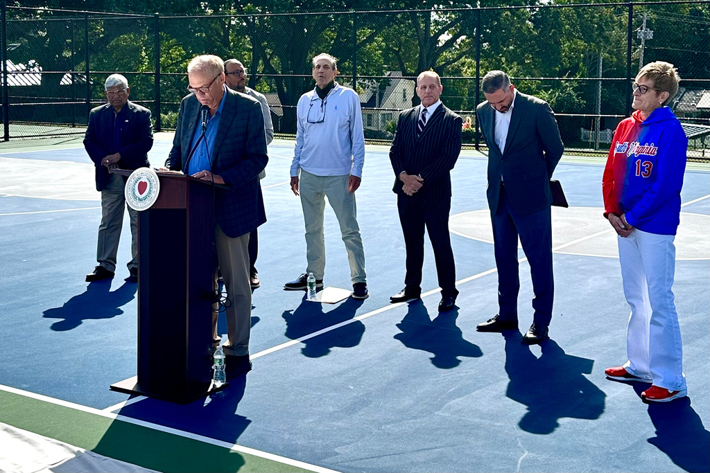 Mayor Joseph Petty speaks at the podium during a court dedication ceremony.