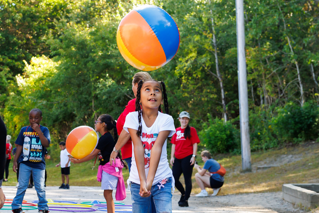 A student volleys a beachball during outdoor play.