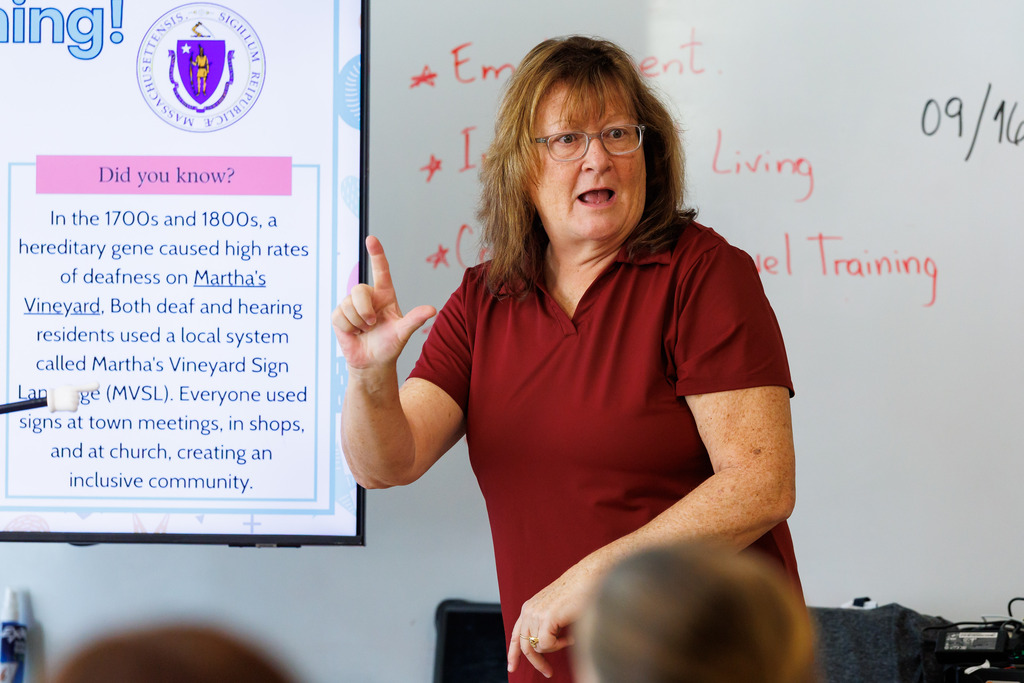 A teacher signs to the classroom.
