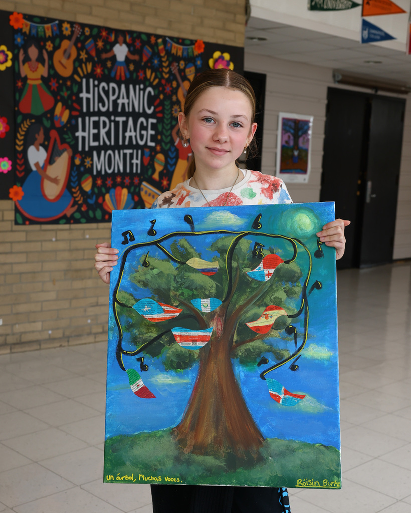 Roisin B. stands with their artwork.
