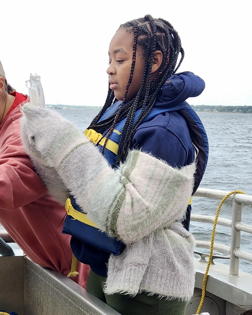 Students participate in a learning activity while on a boat.