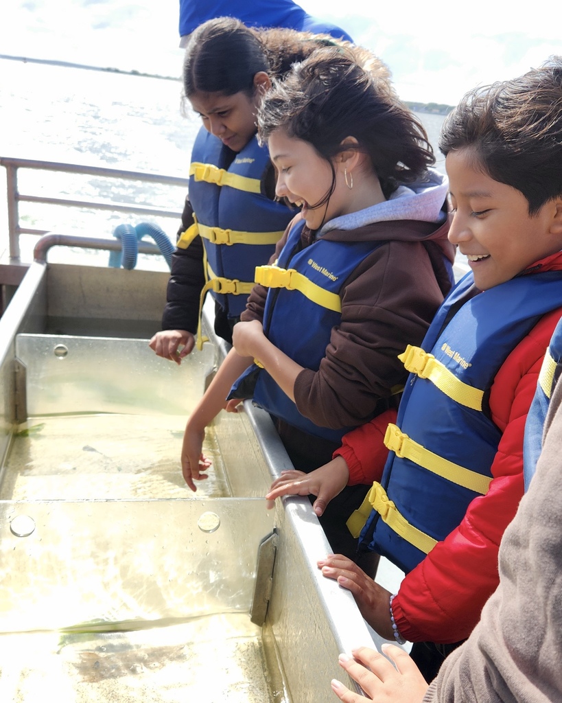 Students participate in a learning activity while on a boat.