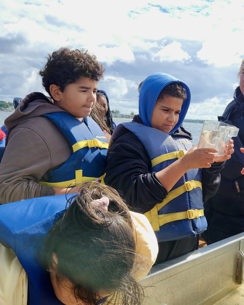 Students participate in a learning activity while on a boat.