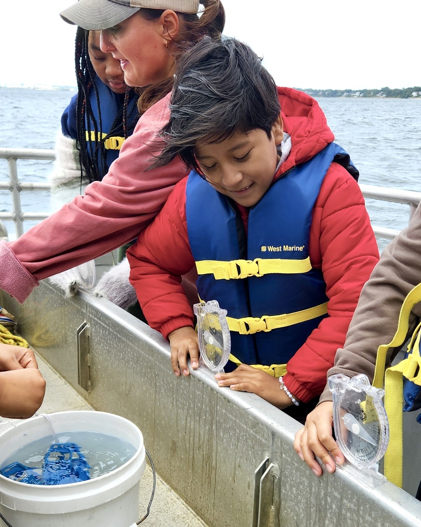 Students participate in a learning activity while on a boat.