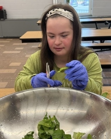 Students and staff in the WPS Transition Program clean and prepare vegetables for eating.