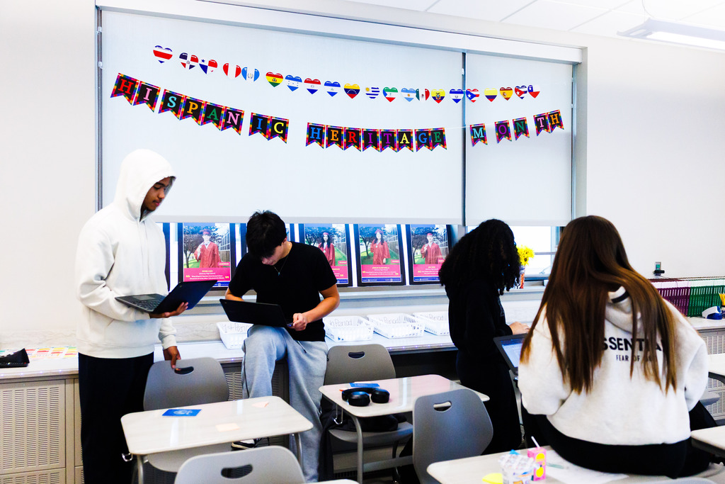 Students work together under a banner that says "Hispanic Heritage Month"